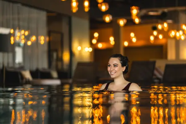 Overdekt zwembad Een vrouw lacht in het zwembad.