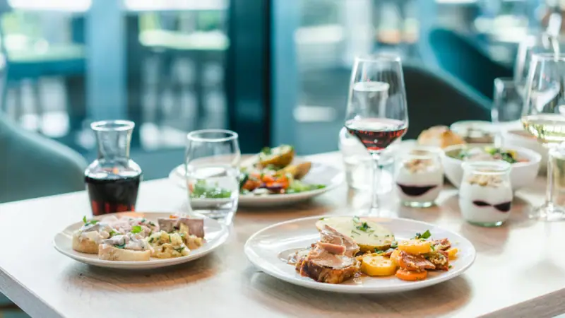 Een tafel met borden vol eten en wijnglazen.