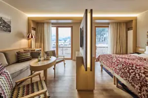 Een kamer met een bed, een tafel en stoelen.