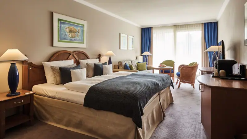 Hotelkamer met bed en stoelen, elegant ingericht en gedecoreerd.