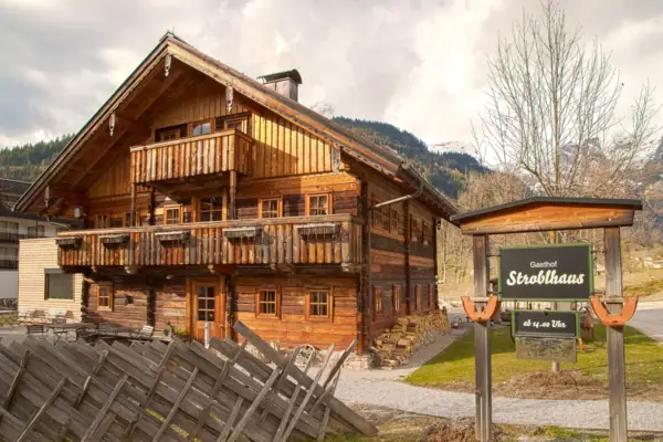 Strobhaus Werfenweng Een houten huis met een bord ervoor.
