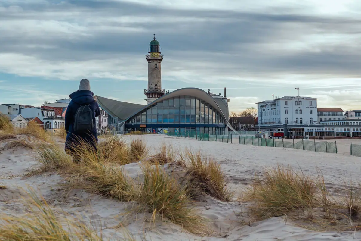 Warnemünde in de winter Iemand die over het strand wandelt.