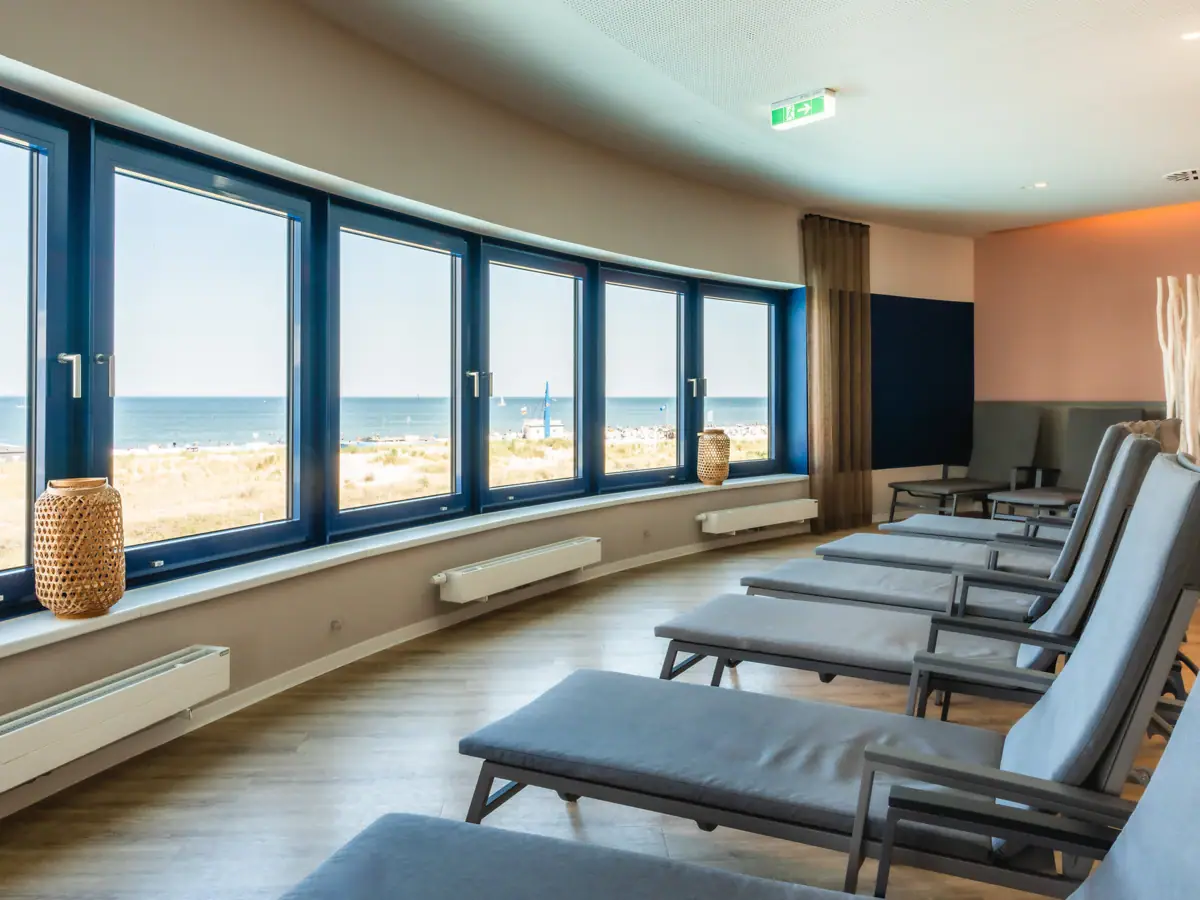 Ontspanningsruimte bij de aja Warnemünde Een kamer met stoelen en ramen, ontworpen in een modern interieur. Met uitzicht op de Baltische Zee.