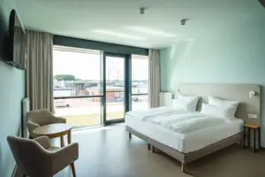 Mindervalide kamer Een slaapkamer met een bed en stoelen.