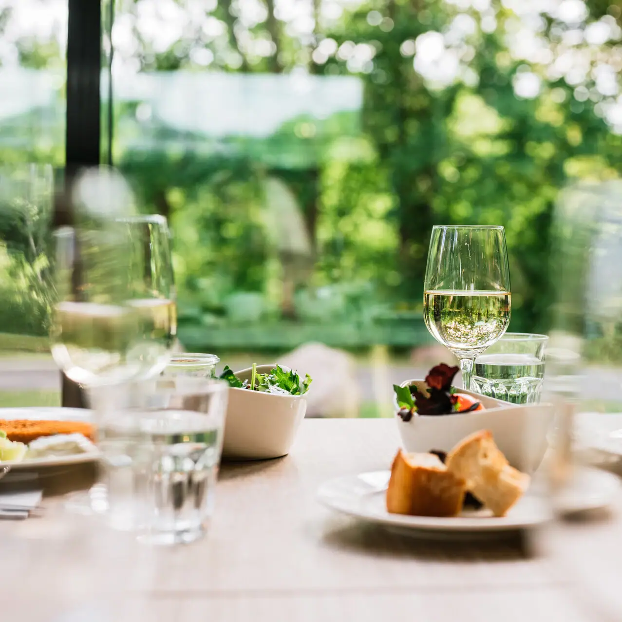 Eten en drinken bij aja Bad Saarow Een tafel met verschillende borden en wijnglazen.