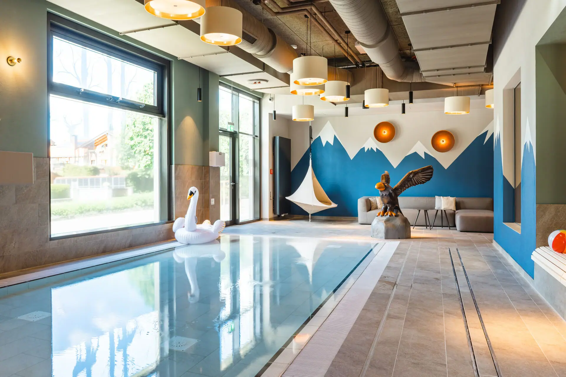 Kinderzwembad Een zwembad met een zwaan en een vogelsculptuur.