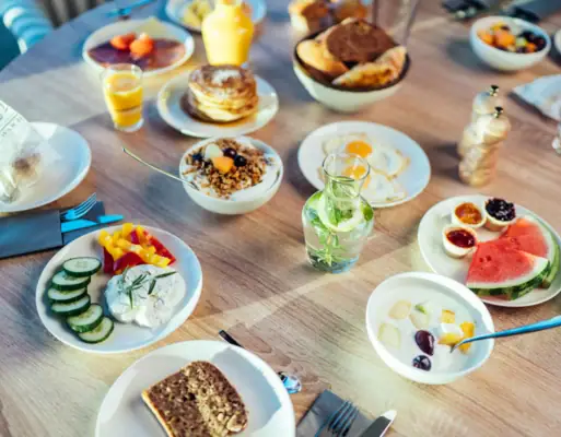 Een tafel met borden vol eten en drinken.