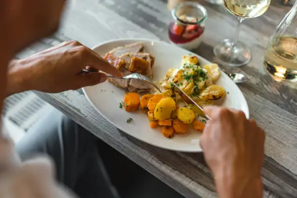 Iemand eet voedsel van een bord.