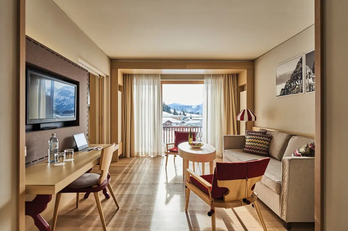 Een kamer met een tafel, stoelen en een televisie.