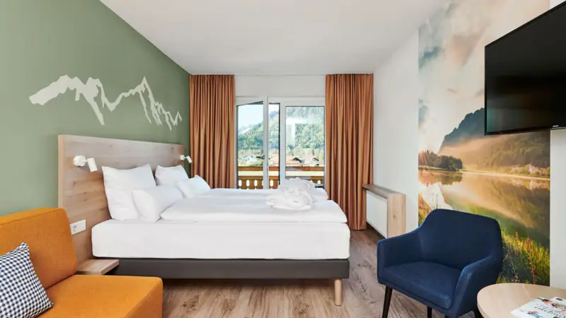 Een kamer met een bed en een stoel.