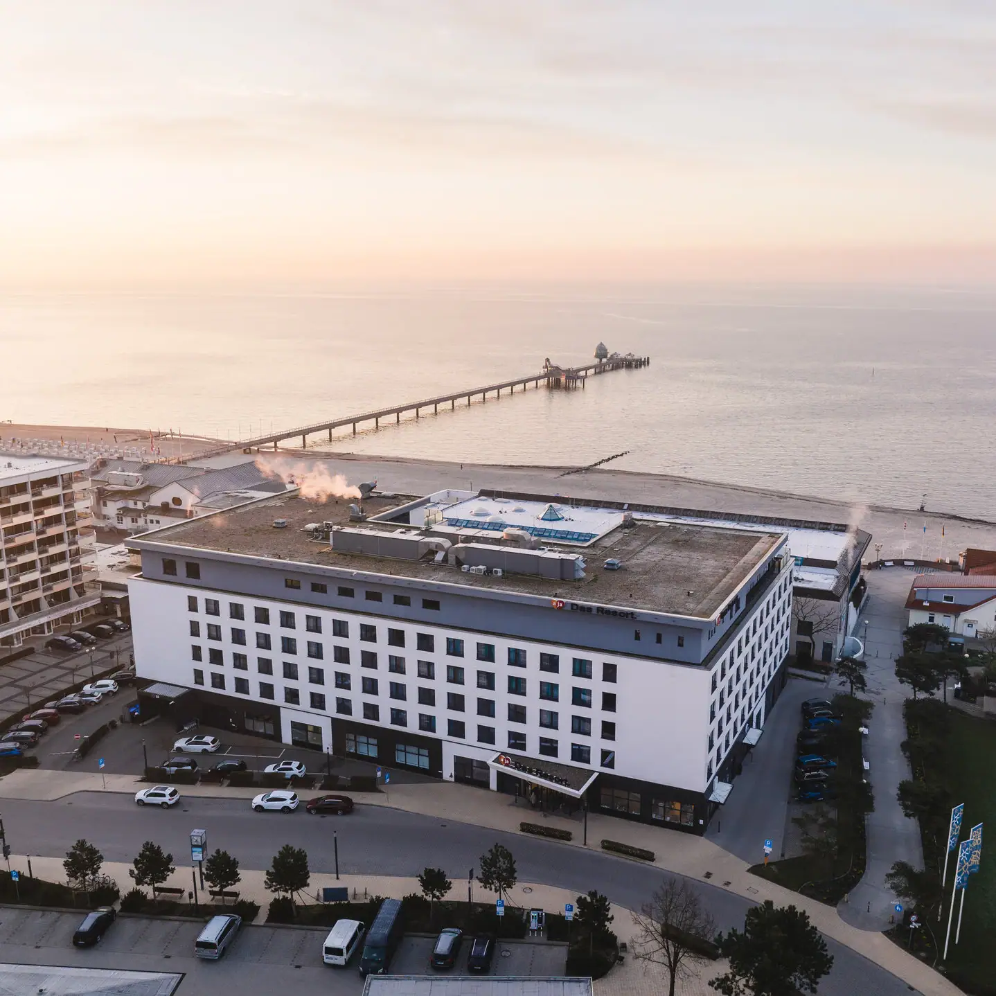 Een gebouw naast een watermassa onder een bewolkte hemel.