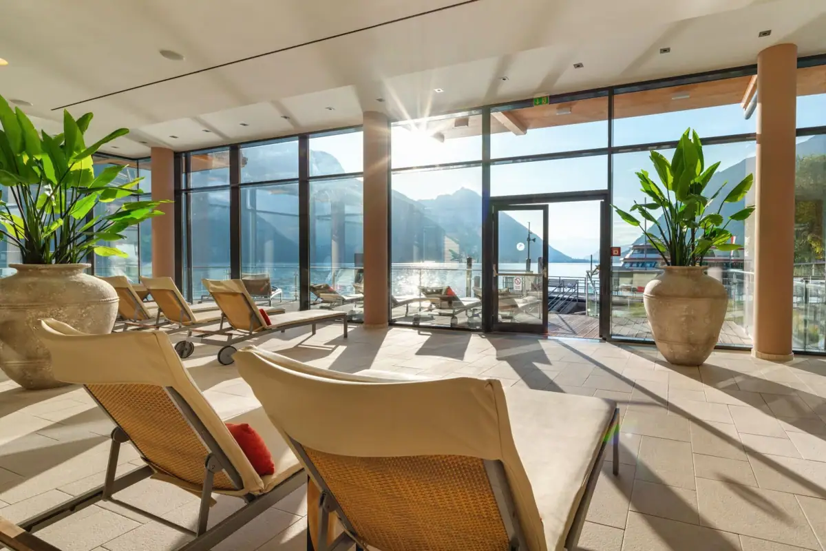 Ontspanningsruimte met uitzicht op het meer Een kamer met stoelen en een grote glazen deur.