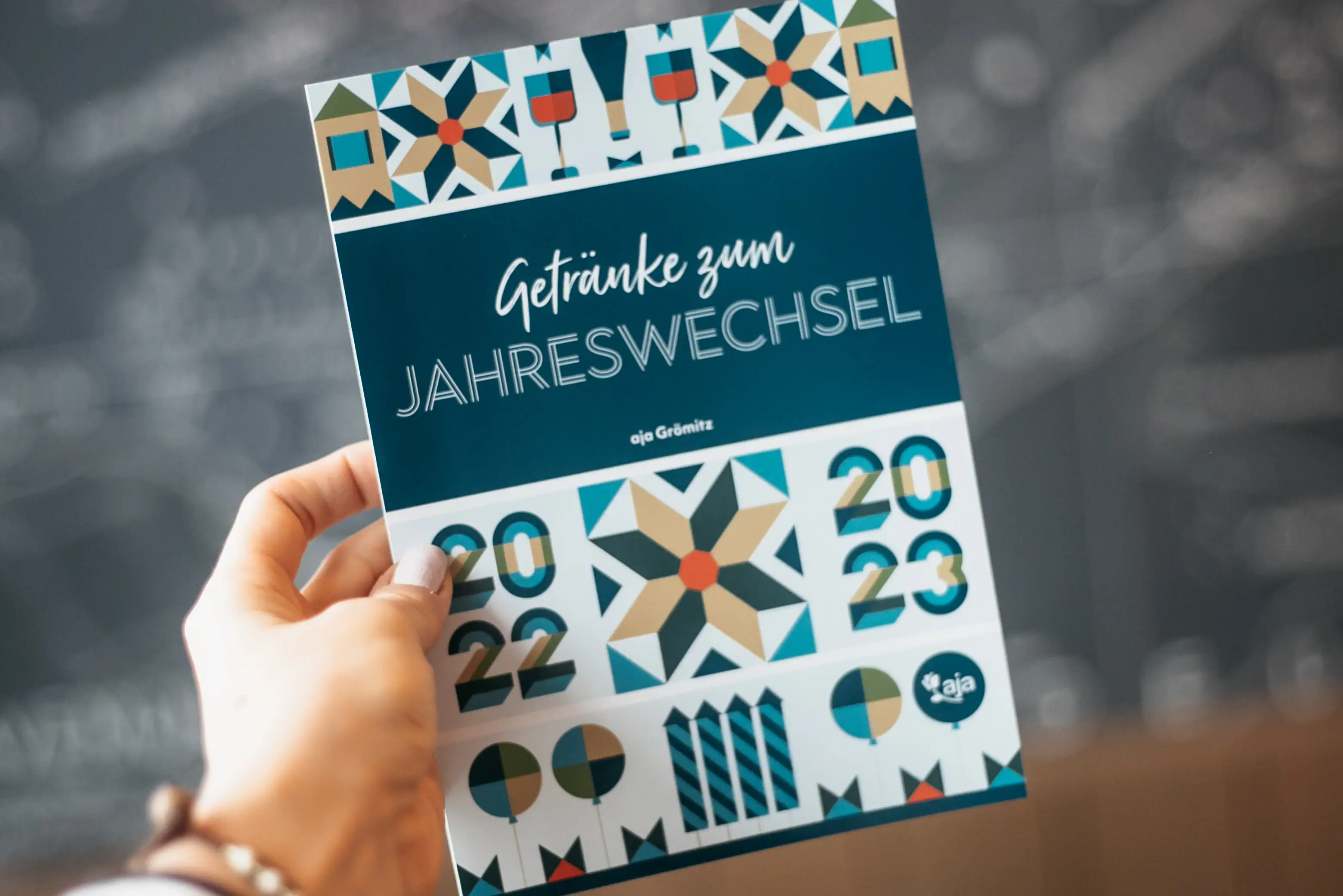 Eén hand houdt een programmaboekje vast voor het nieuwjaarsfeest.