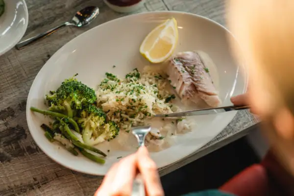 Persoon eet van een bord eten.