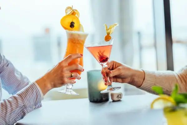 Cocktails Een paar handen houden glazen met drankjes vast.