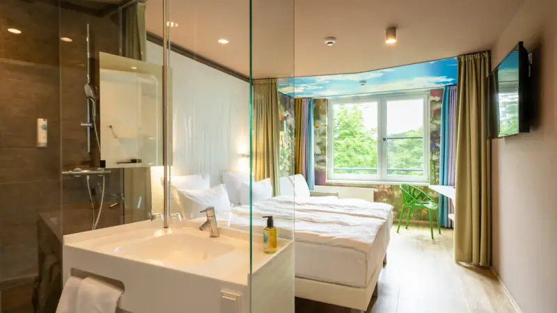 Kamers in het aja Bad Saarow Een kamer met een glazen douche en twee bedden.