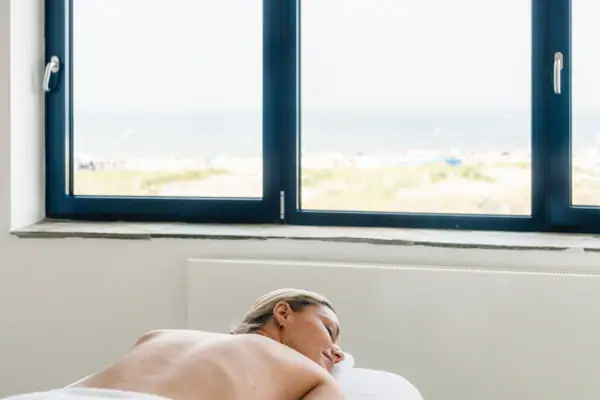 Een vrouw ligt op een massagetafel.