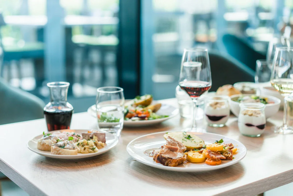 Een tafel met borden vol eten en glazen wijn.