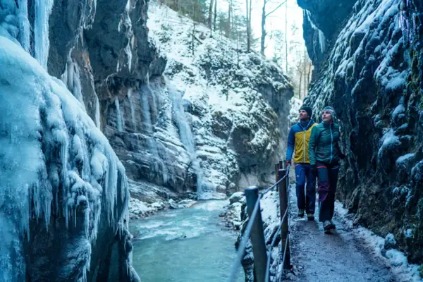 Twee mensen wandelen in de winter door de Partnachklamm.